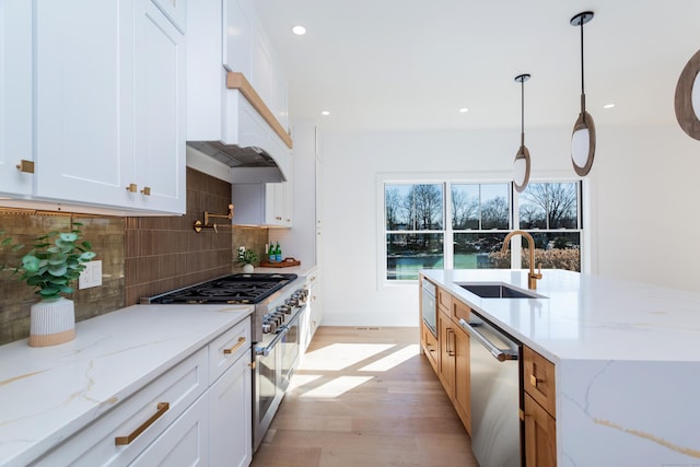 kitchen featuring appliances with stainless steel finishes, sink, white cabinets, and light stone counters