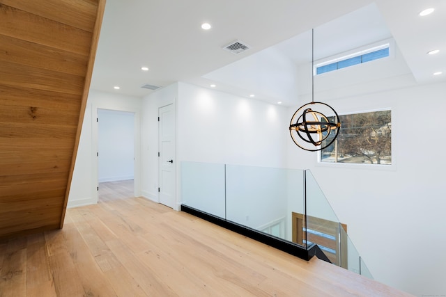 hallway featuring plenty of natural light, a chandelier, and light wood-type flooring