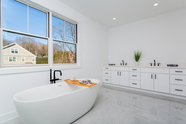 bathroom featuring a washtub and vanity