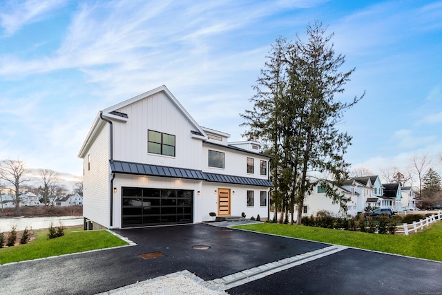 modern farmhouse style home featuring a garage and a front lawn