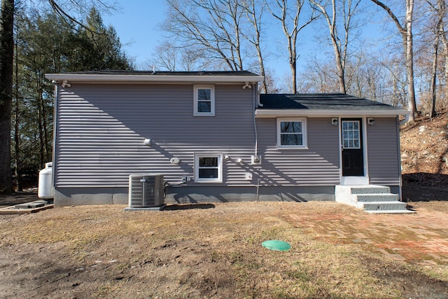 back of property with cooling unit and a lawn