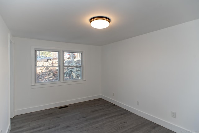 spare room featuring dark wood-type flooring