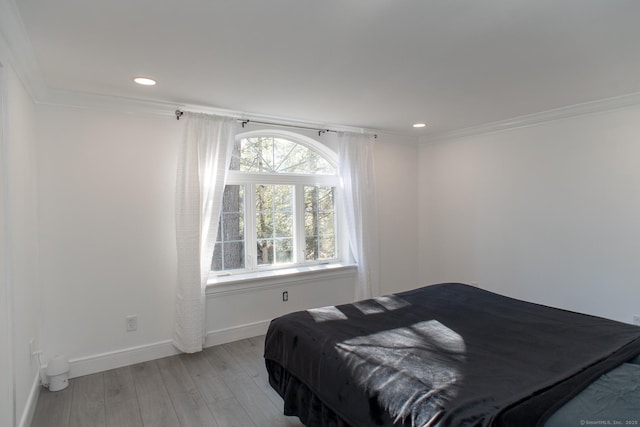 bedroom featuring ornamental molding and light hardwood / wood-style floors