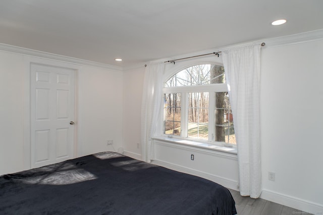 unfurnished bedroom featuring multiple windows, hardwood / wood-style flooring, and ornamental molding