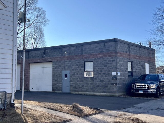 exterior space with a garage and cooling unit