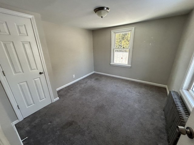 carpeted spare room with radiator heating unit