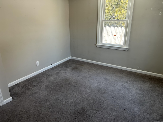 spare room with dark colored carpet