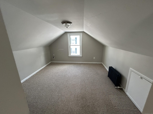 bonus room featuring lofted ceiling, radiator, and carpet flooring