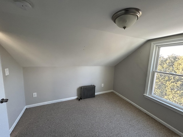 bonus room featuring carpet floors, a wealth of natural light, radiator heating unit, and vaulted ceiling