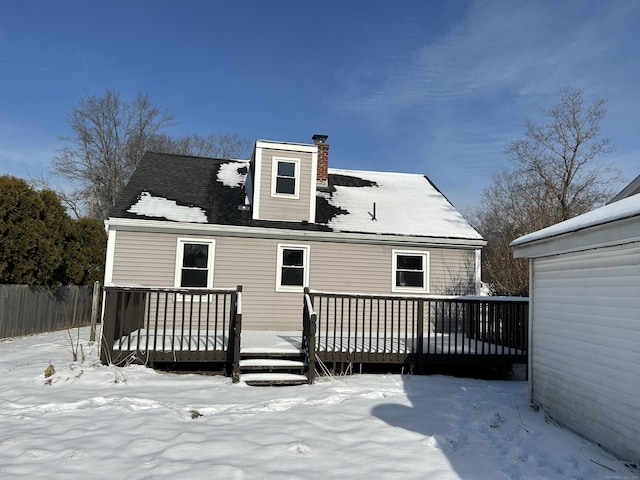 snow covered house featuring a deck