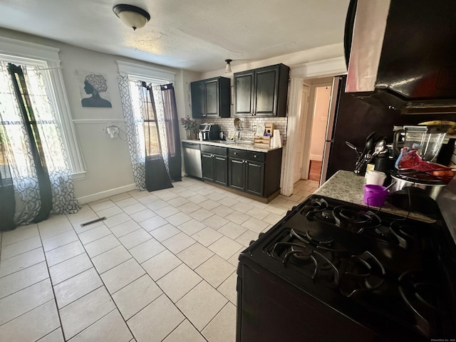 kitchen with tasteful backsplash, dishwasher, black gas range, and light tile patterned floors