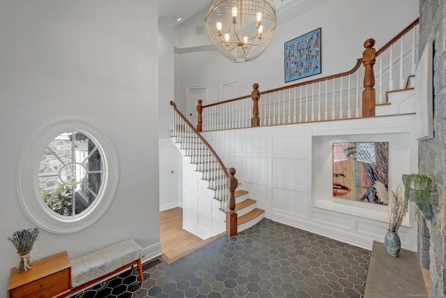 foyer entrance featuring a notable chandelier, stairway, and a high ceiling