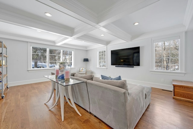 living room featuring a wealth of natural light, visible vents, and beamed ceiling