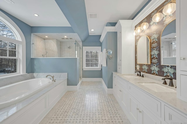 full bathroom featuring a garden tub, a stall shower, a sink, and baseboards