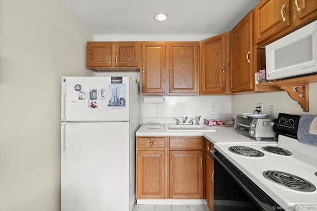 kitchen featuring sink, white appliances, and a textured ceiling