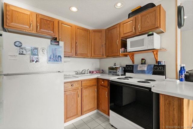 kitchen with white appliances, sink, and light tile patterned floors