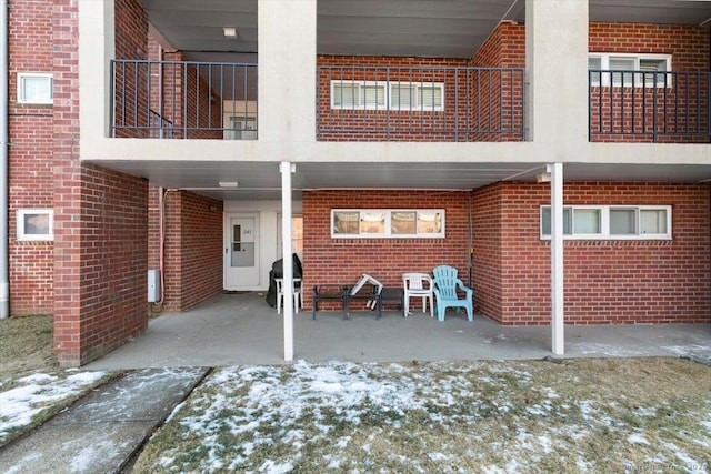 snow covered house featuring a patio area