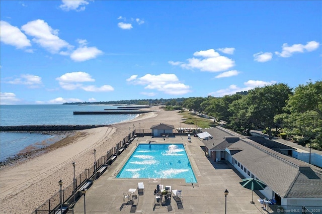 view of pool with a patio and a water view