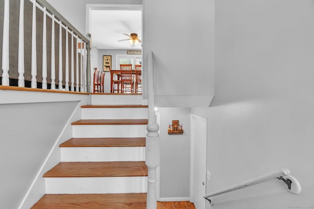 stairs featuring ceiling fan