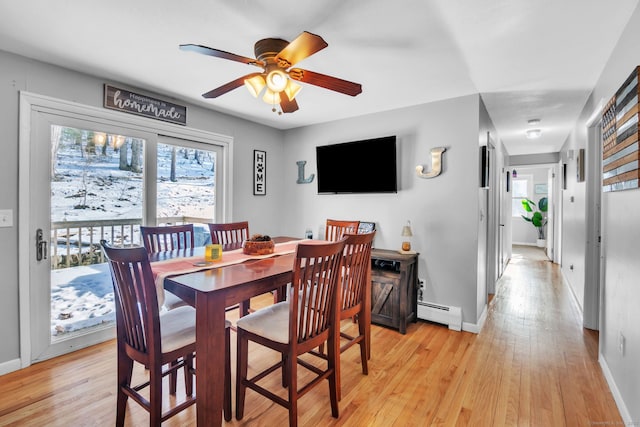 dining room with ceiling fan, a baseboard radiator, and light hardwood / wood-style flooring