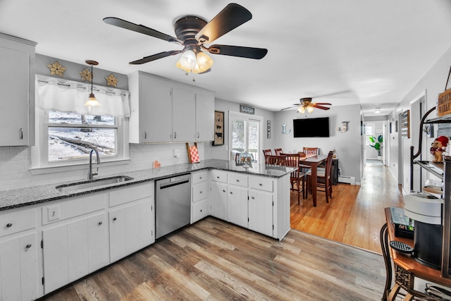 kitchen with sink, white cabinetry, light stone counters, dishwasher, and pendant lighting