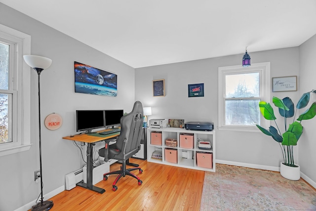 office with wood-type flooring and baseboard heating