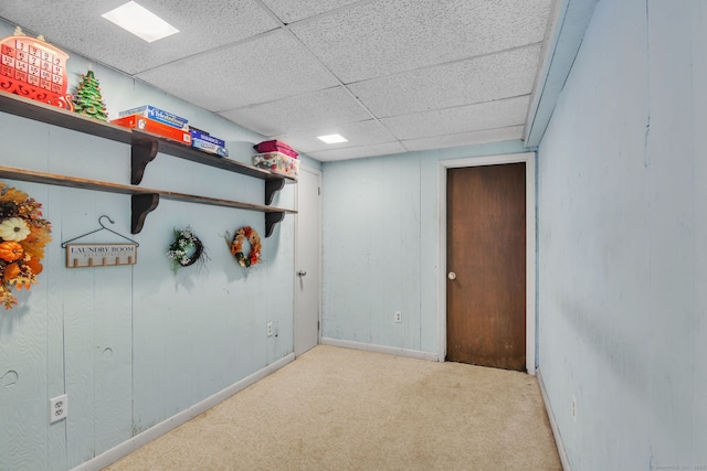 interior space featuring a paneled ceiling and light carpet