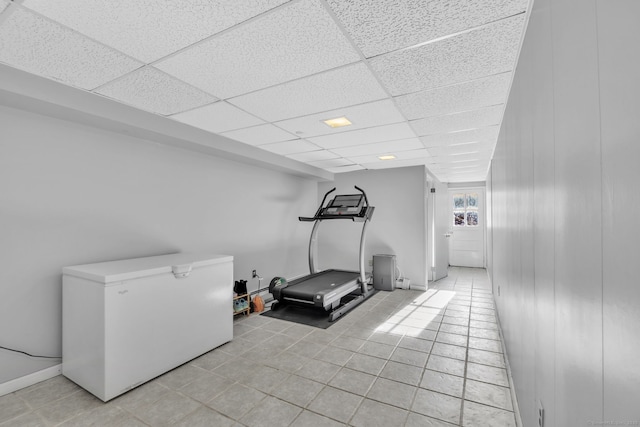 exercise room featuring light tile patterned flooring and a drop ceiling