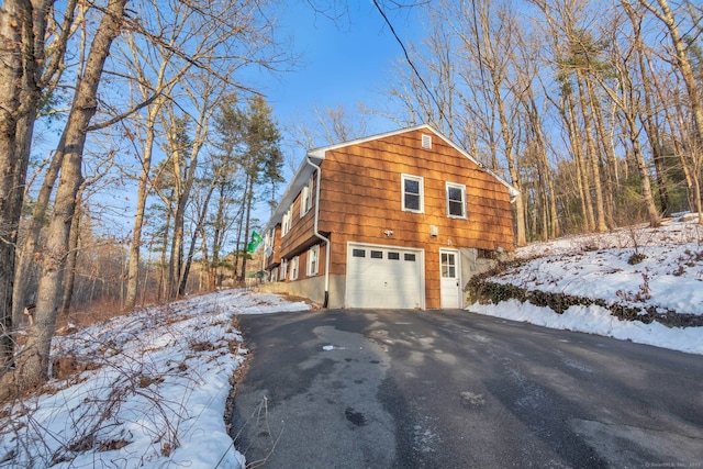 view of snowy exterior featuring a garage