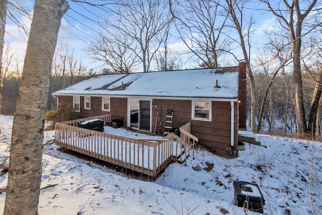 snow covered rear of property featuring a deck