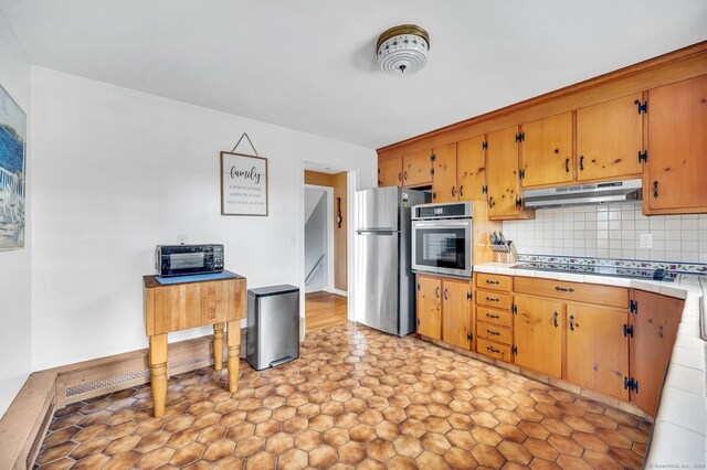 kitchen with tasteful backsplash, tile counters, and black appliances