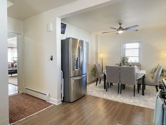 dining area with crown molding, dark wood-type flooring, ceiling fan, and baseboard heating