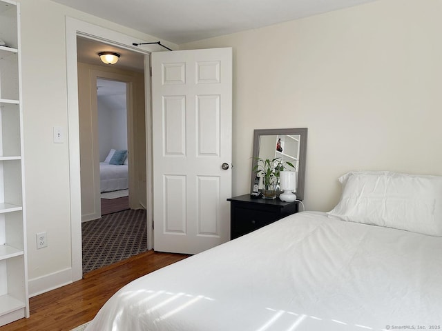 bedroom with dark wood-type flooring