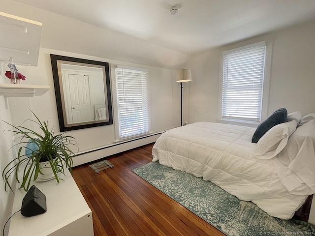 bedroom featuring multiple windows, a baseboard heating unit, dark wood-type flooring, and lofted ceiling