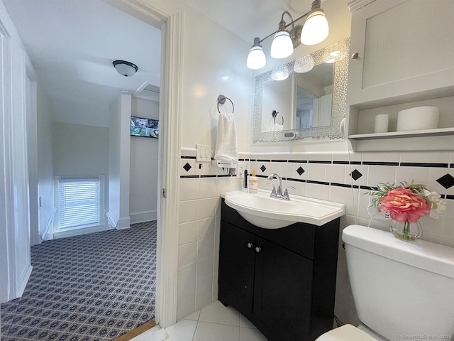 bathroom with tile patterned flooring, vanity, tile walls, and toilet