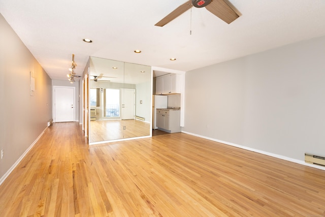 interior space with light hardwood / wood-style floors, ceiling fan, and baseboard heating