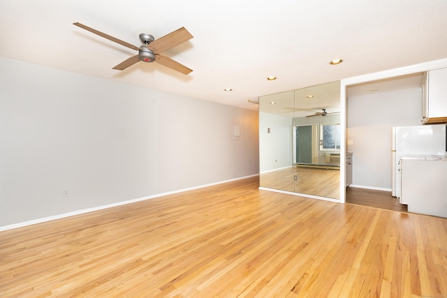 unfurnished living room featuring ceiling fan and light hardwood / wood-style floors