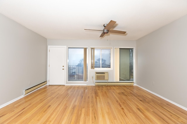 spare room featuring a baseboard heating unit, light hardwood / wood-style floors, a wall mounted AC, and ceiling fan