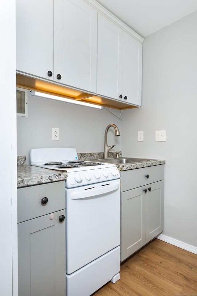 kitchen featuring white cabinetry, sink, light wood-type flooring, and white range with electric cooktop