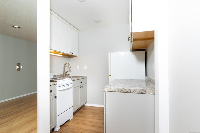 kitchen with sink, white cabinets, white appliances, and light hardwood / wood-style floors