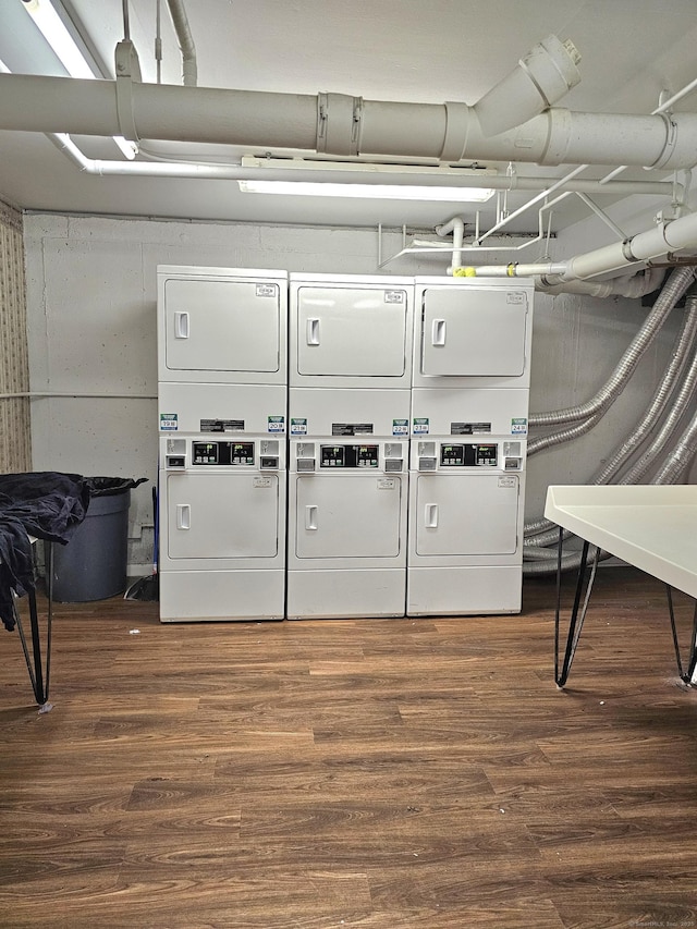 laundry room with stacked washer / dryer and dark hardwood / wood-style flooring