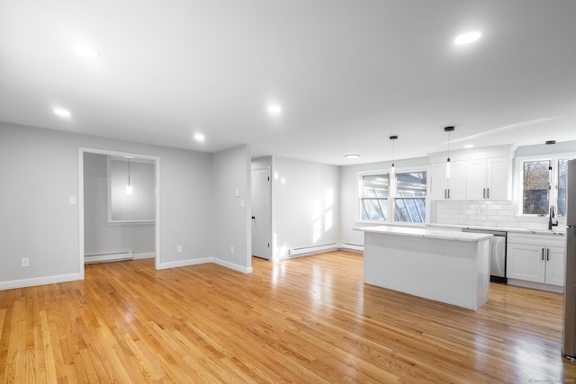 kitchen featuring white cabinetry, backsplash, a kitchen island, decorative light fixtures, and a baseboard radiator