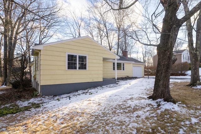 view of snow covered exterior featuring a garage