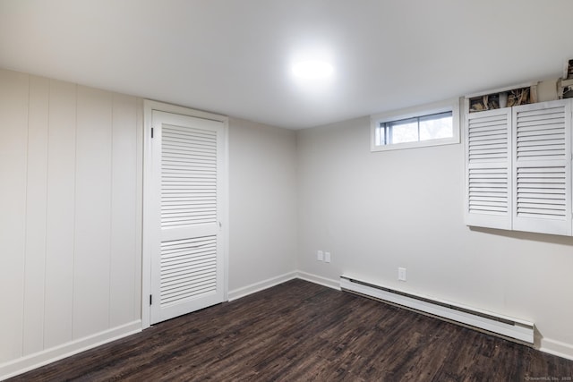 unfurnished bedroom featuring a baseboard radiator, dark wood-type flooring, and a closet