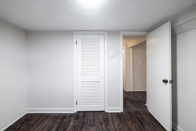 unfurnished bedroom featuring dark wood-type flooring and a closet