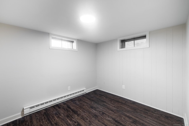 basement featuring dark wood-type flooring and a baseboard radiator