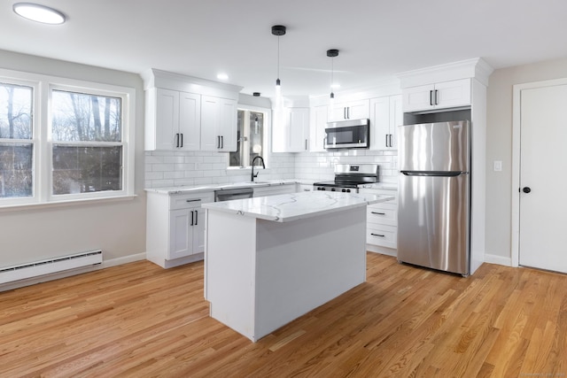 kitchen featuring white cabinetry, decorative light fixtures, a center island, appliances with stainless steel finishes, and light hardwood / wood-style floors