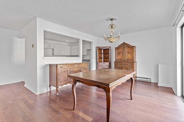 dining room featuring an inviting chandelier, a baseboard radiator, and light wood-type flooring