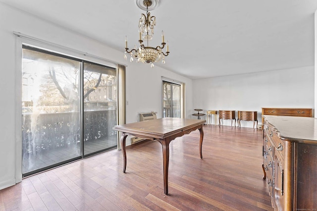 dining area featuring hardwood / wood-style flooring and a notable chandelier