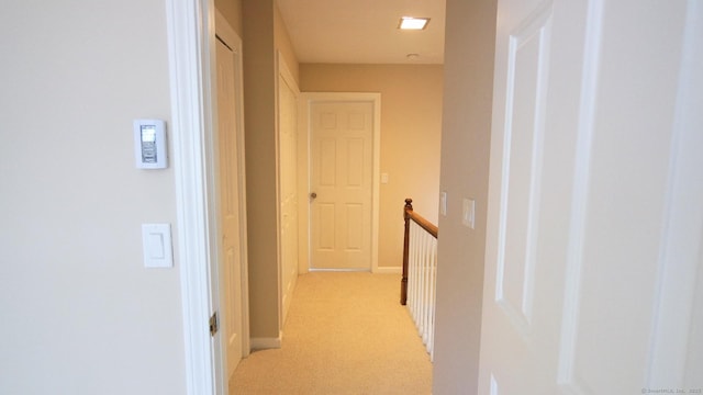 hallway featuring light colored carpet